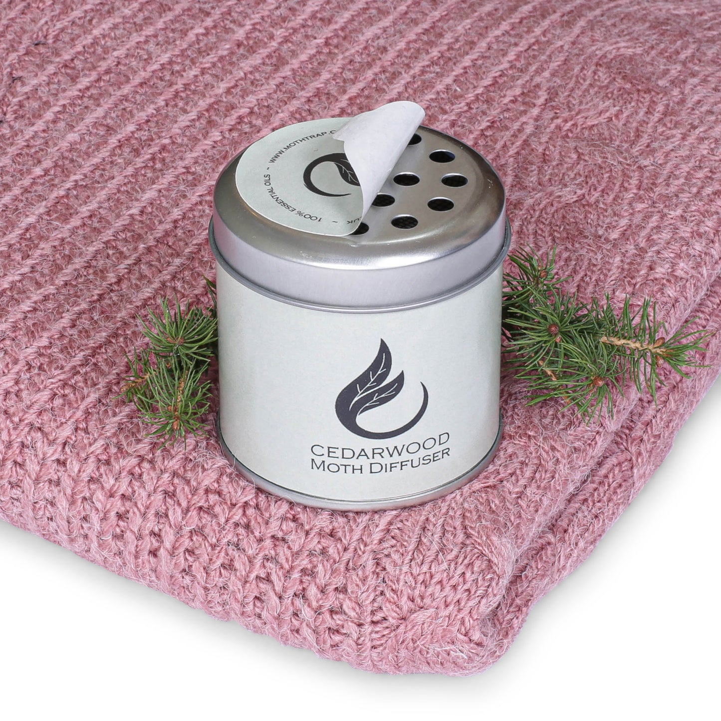 cedarwood moth repellent diffuser tin with cedarwood on a pink jumper