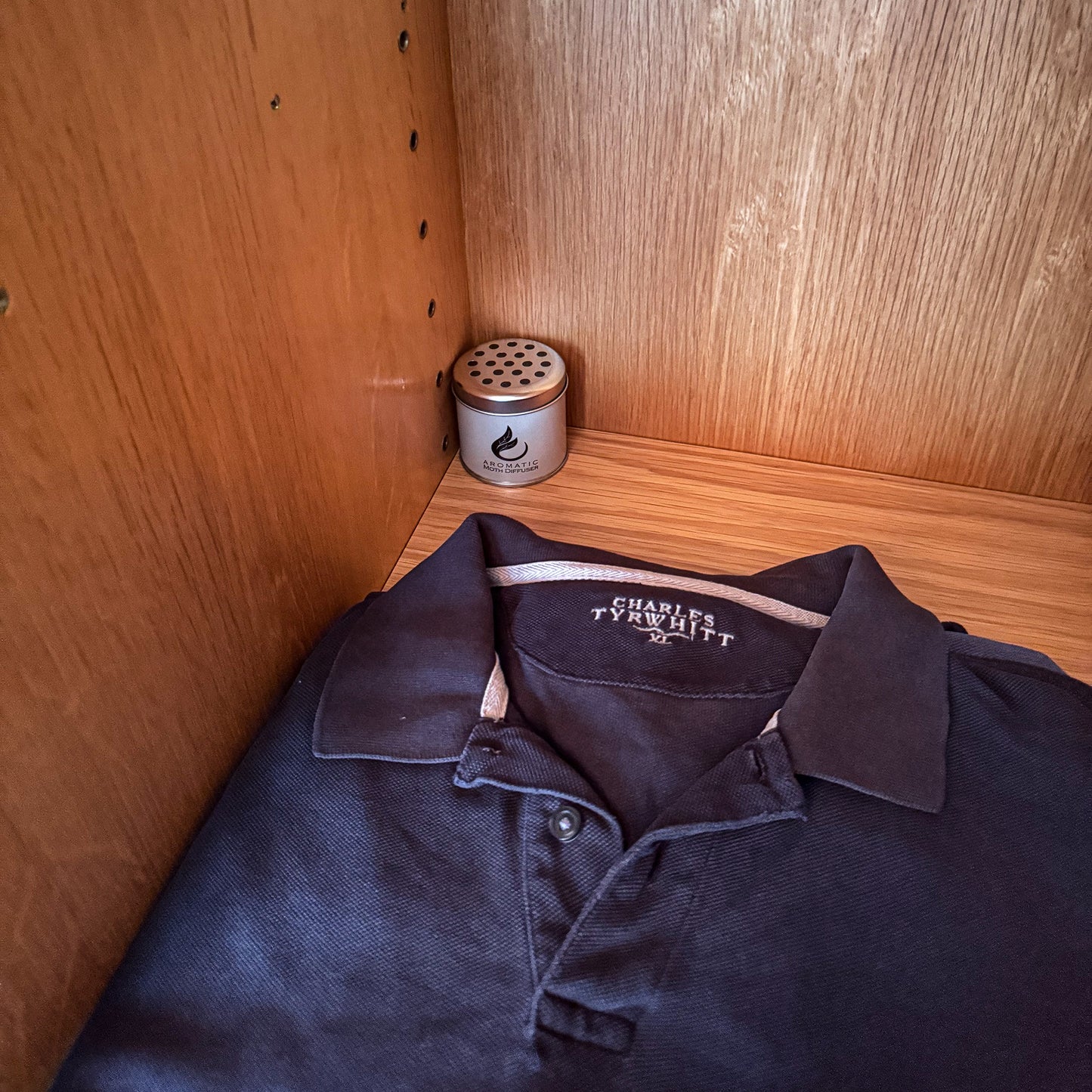 aromatic moth repellent diffuser tin in drawer with blue polo shirt