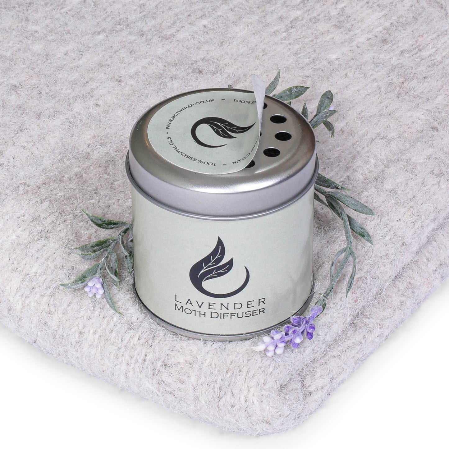 lavender moth repellent diffuser tin on a grey jumper with lavender plant