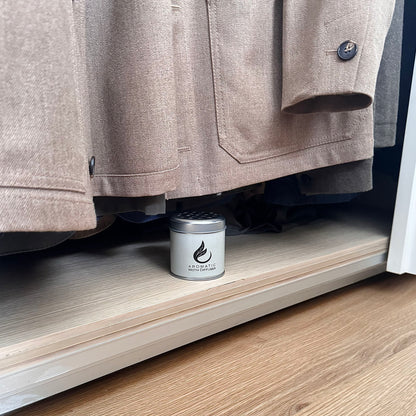Cabinet with a beige coat and a moth repellent diffuser on a shelf.